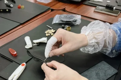 Beginner friendly leather craft process showing hands stitching a leather tote bag DIY kit