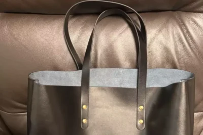 Black genuine leather tote bags handmade by participants during a DIY bag workshop